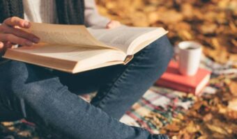 A person reads books for personal success and self-help