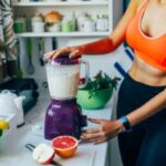 Straight-belly woman mixes smoothies in blender