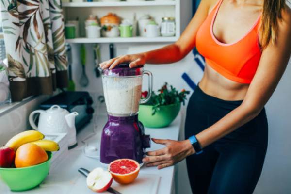 Straight-belly woman mixes smoothies in blender