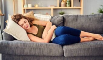 a person with chronic gastritis lies on the couch and clings to the stomach