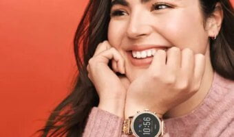 Smiling girl wears a smartwatch on her hand